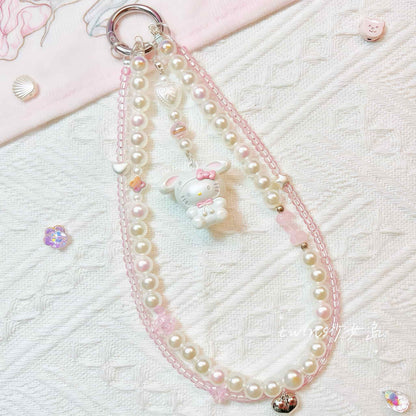 Close-up detail of Y2K style Hello Kitty decoden phone case with baroque pearls and pink accents